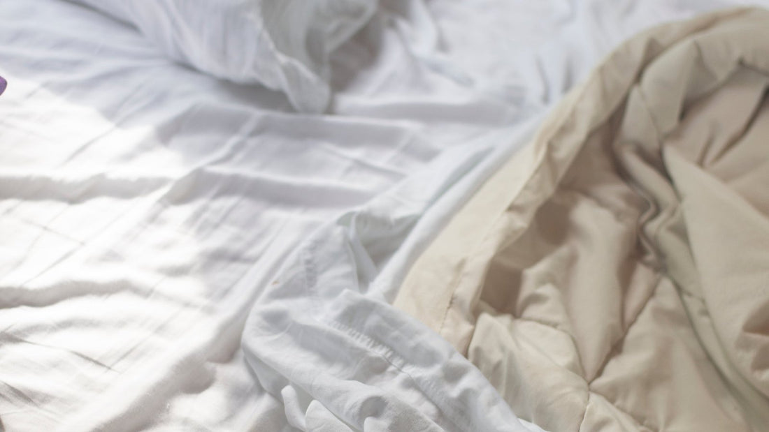 Witte kussens en lakens op een onopgemaakt bed