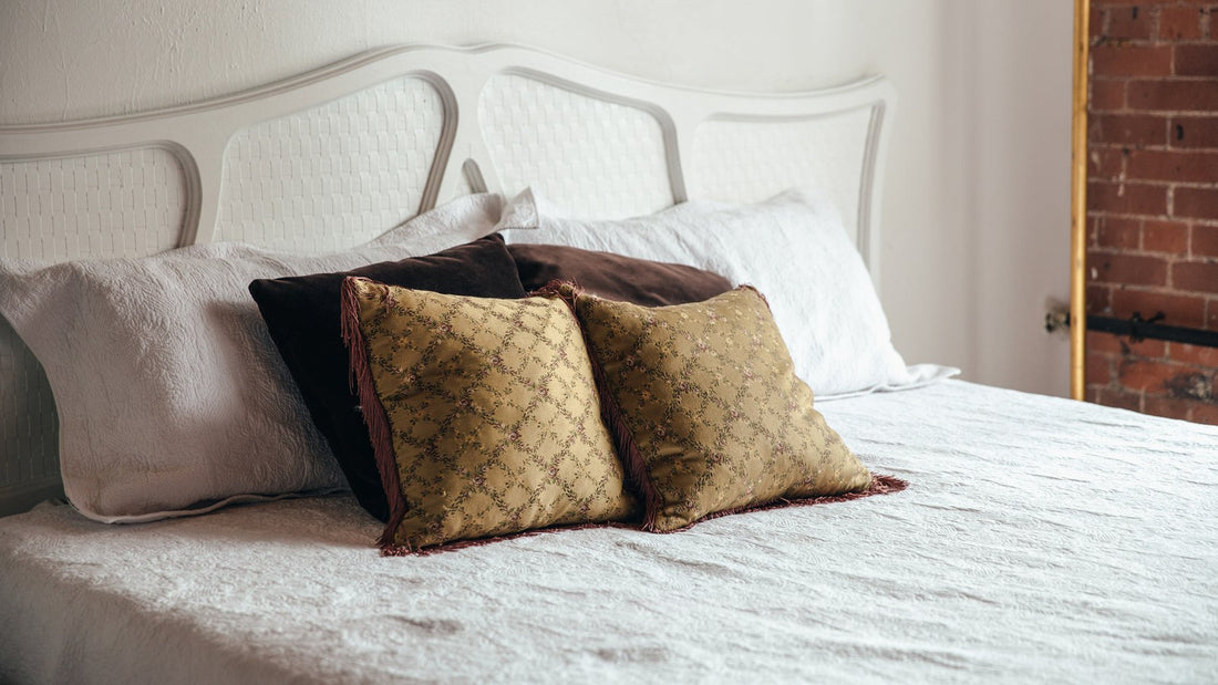 Rustig opgemaakt bed met witte lakens en kussens