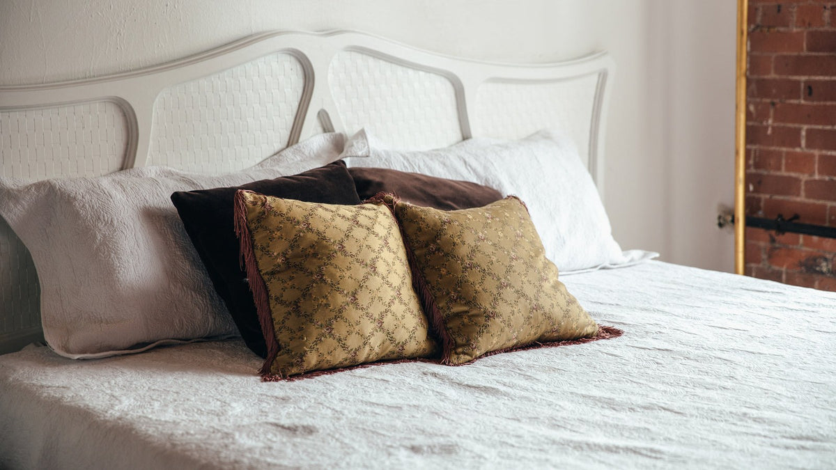Rustig opgemaakt bed met witte lakens en kussens