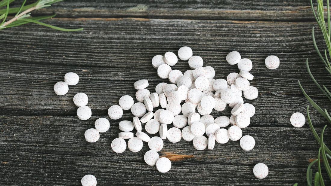 Witte tabletten en capsules op donker hout