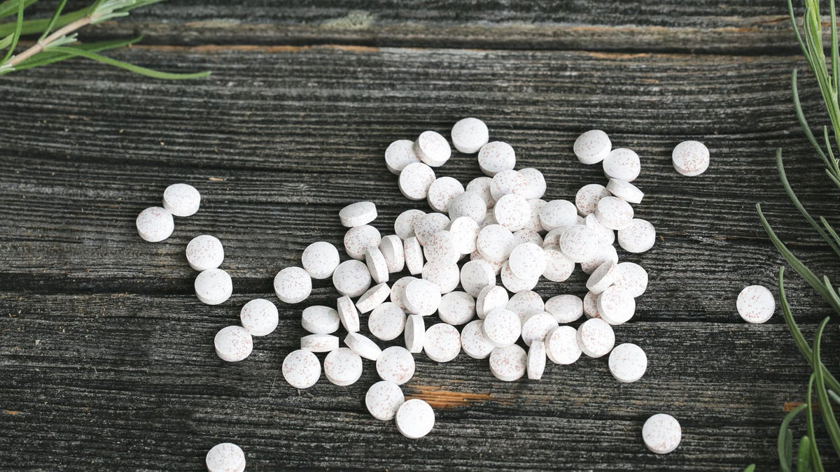 Witte tabletten en capsules op donker hout