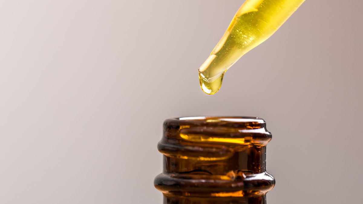 Olie druppelt in een amberkleurig flesje