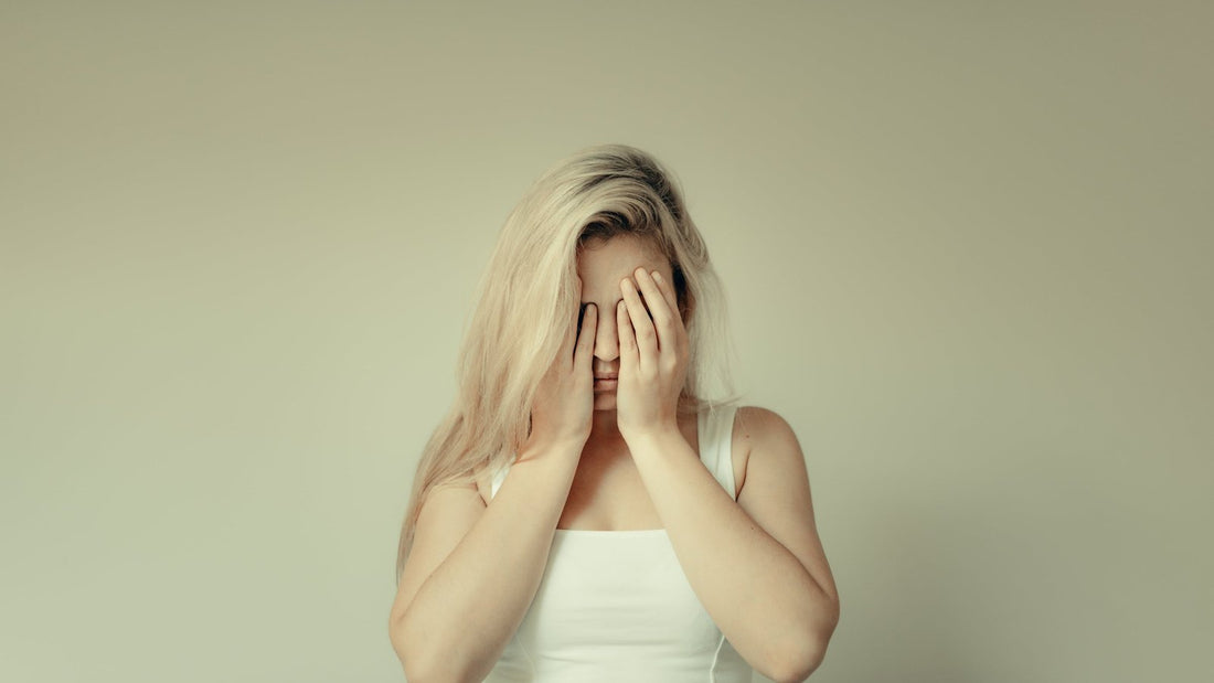 Vermoeide vrouw met haar handen voor haar gezicht