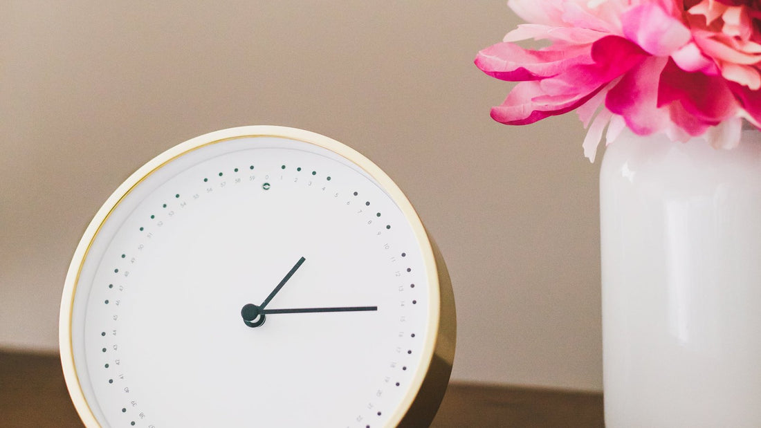 Klok en bloemen op een bijzettafel