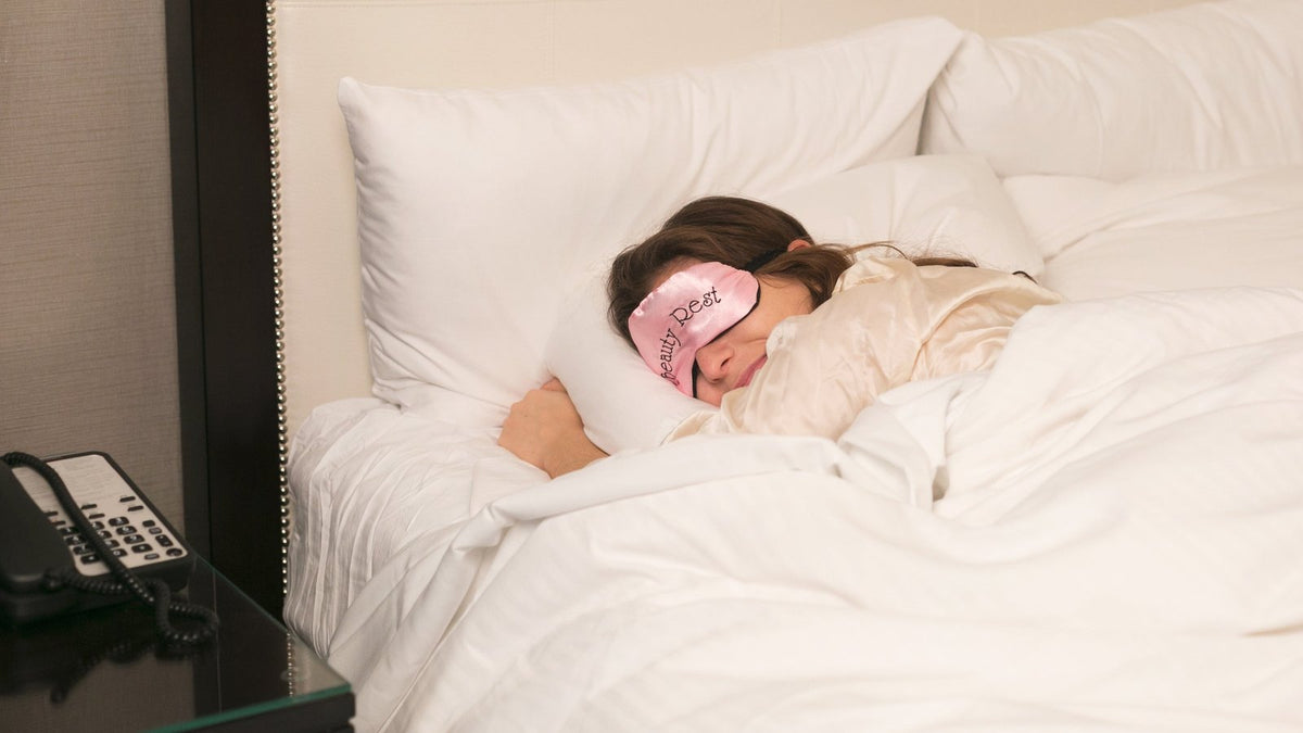 Iemand slaapt in een wit opgemaakt bed