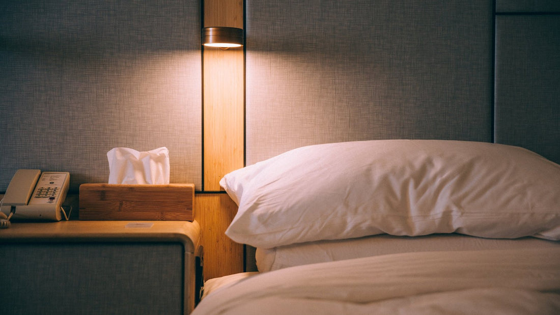 Rustige slaapkamer met een opgemaakt bed en een warme lamp