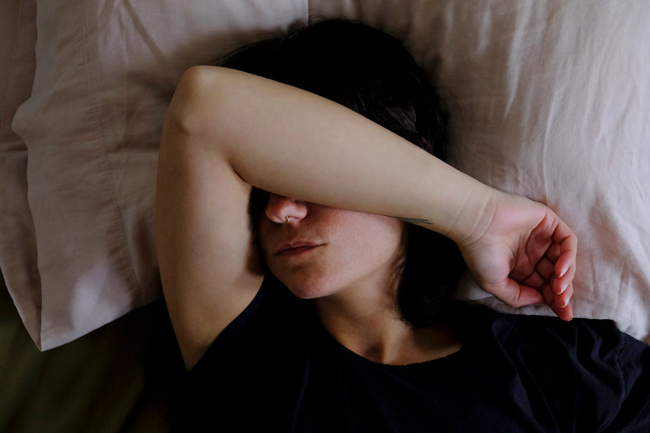 Wakker liggen in bed, arm over het gezicht